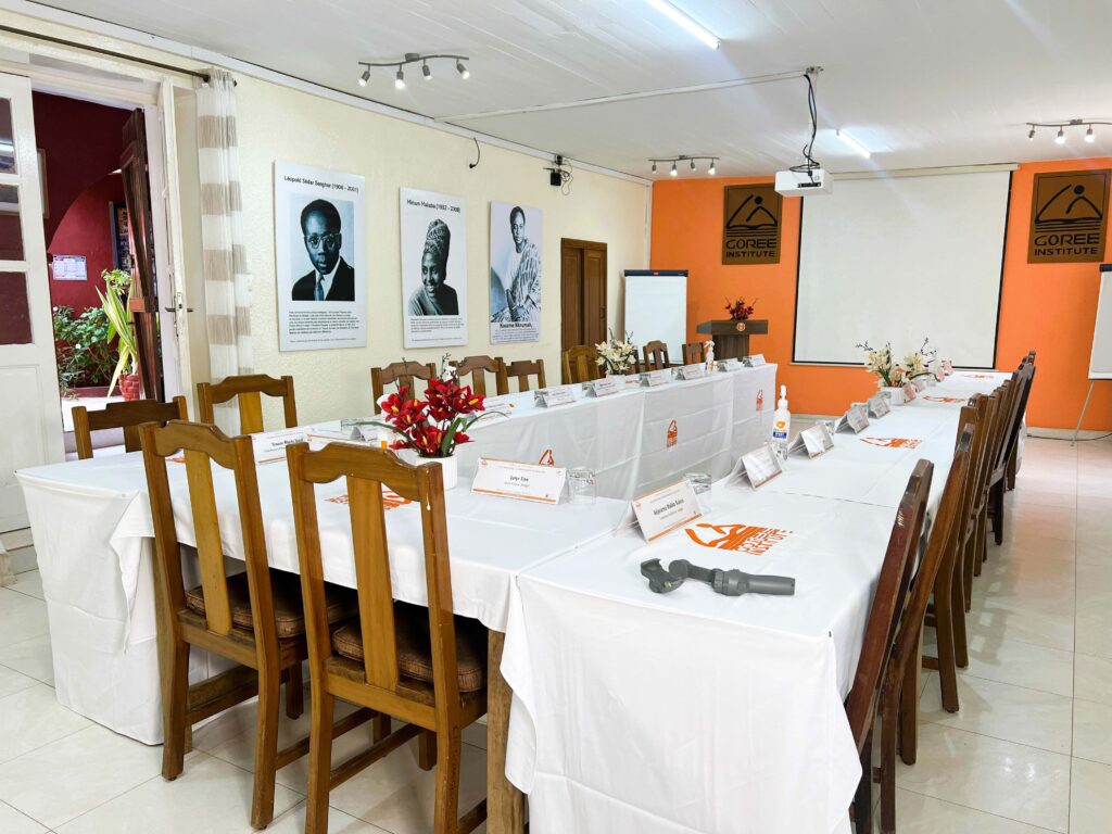 Centre de conférence TERAL 2 Salle de conférence de TERAL dressée en U, tables nappées de blanc, portraits de figures africaines au mur