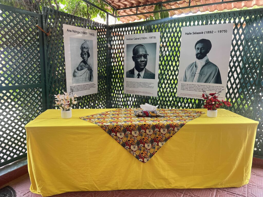 Centre de conférence TERAL 12 Table nappée de jaune sous la terrasse couverte, portraits au mur